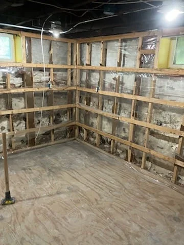 Interior demolition in Boston with exposed framing and subfloor
